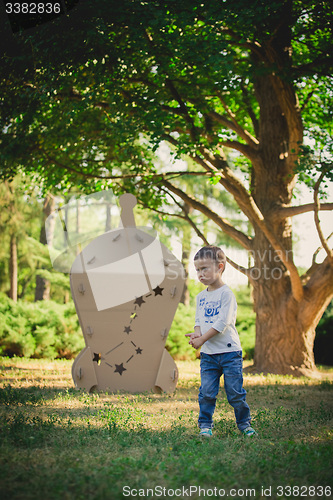 Image of child playing in a cardboard spaceship. Eco concept