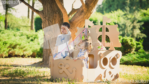 Image of Boy and girl playing in a cardboard boat