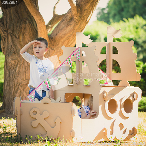 Image of Boy and girl playing in a cardboard boat