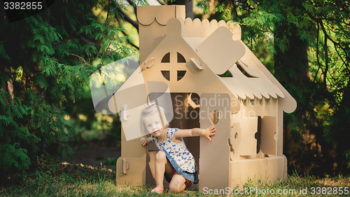 Image of girl playing cardboard house in a city park