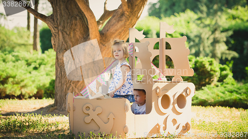 Image of Boy and girl playing in a cardboard boat