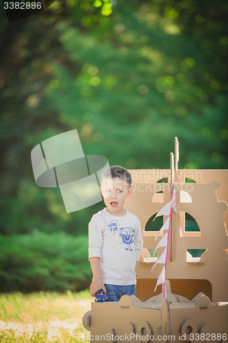 Image of boy plaing in a cardboard boat