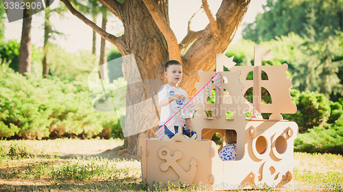 Image of Boy and girl playing in a cardboard boat