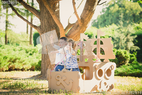 Image of Boy and girl playing in a cardboard boat
