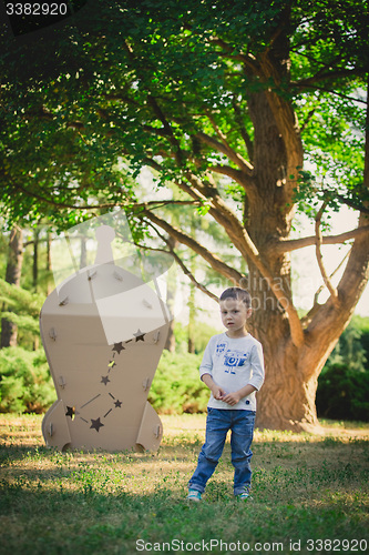 Image of child playing in a cardboard spaceship. Eco concept