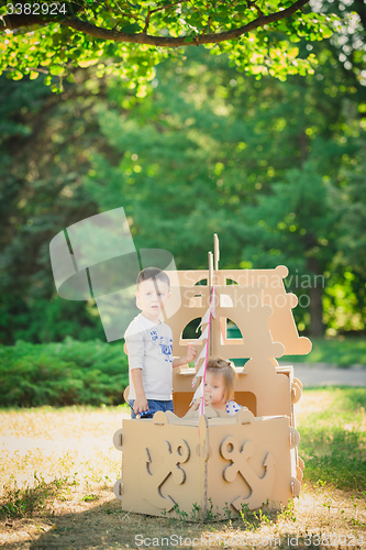 Image of Boy and girl playing in a cardboard boat