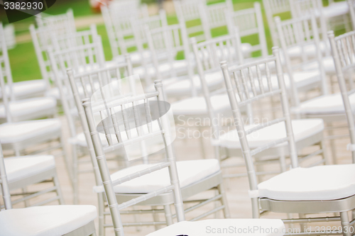 Image of Prior to a wedding ceremony, endless white chairs 