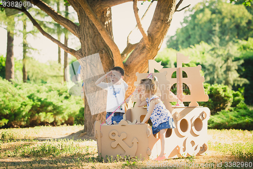 Image of Boy and girl playing in a cardboard boat