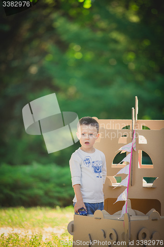 Image of boy plaing in a cardboard boat