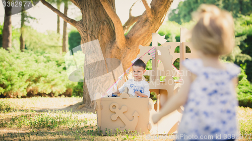 Image of Boy and girl playing in a cardboard boat