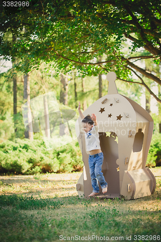 Image of child playing in a cardboard spaceship. Eco concept