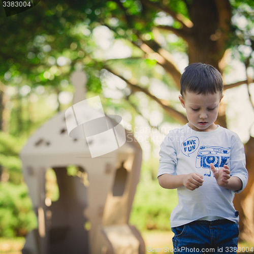 Image of child playing in a cardboard spaceship. Eco concept