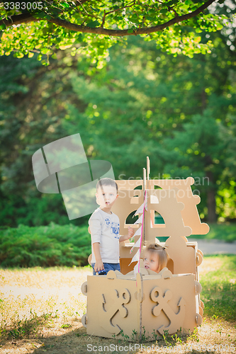 Image of Boy and girl playing in a cardboard boat