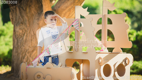 Image of boy plaing in a cardboard boat