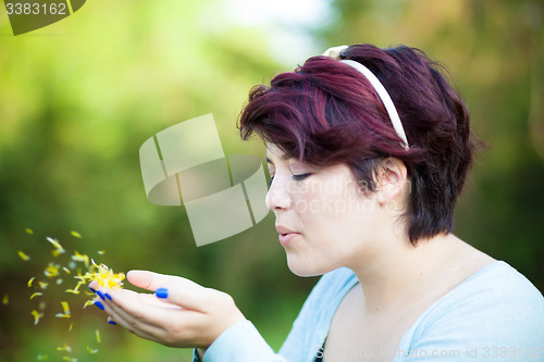 Image of Woman Blowing Flower Petals