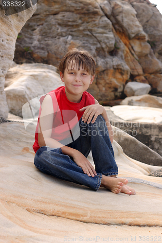 Image of Happy child relaxes on rocks