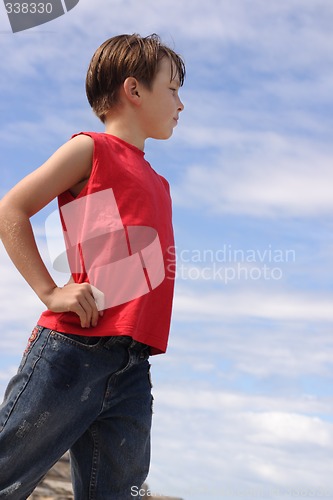 Image of Boy against blue cloudy sky