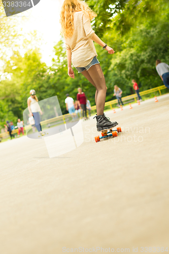 Image of Teenage girl urban long board riding.