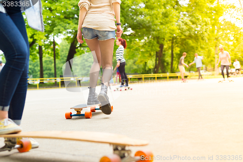 Image of Teenage girl urban long board riding.