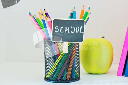 Image of Pencils in holder, yellow appleand book