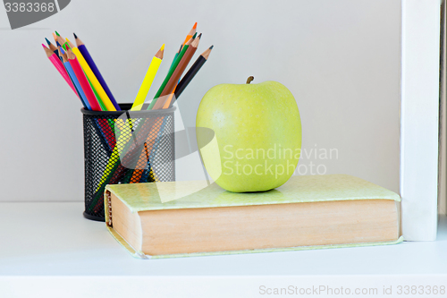 Image of A yellow apple sitting on top of book