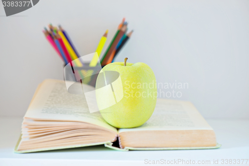 Image of A yellow apple sitting on opened book
