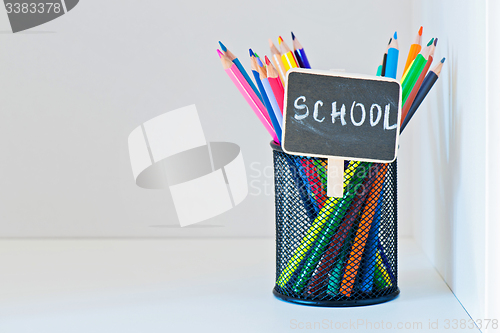 Image of Pencils in a holder on the light-coloured shelf