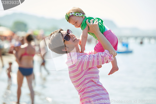 Image of mom and baby on beach  have fun