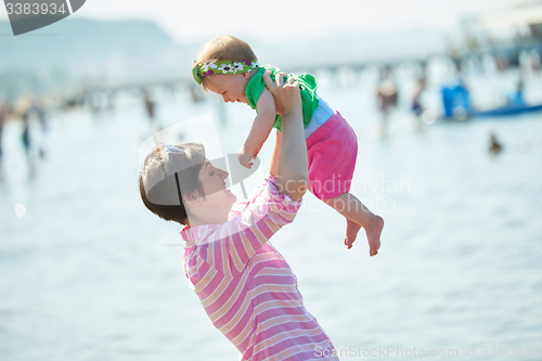 Image of mom and baby on beach  have fun