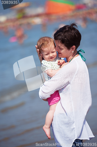 Image of mother walking on beach and push baby carriage