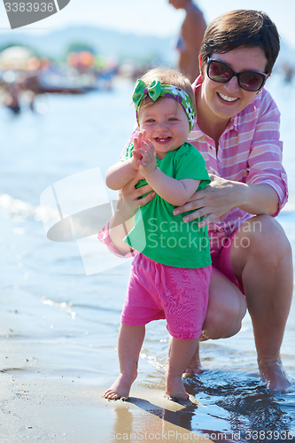 Image of mom and baby on beach  have fun