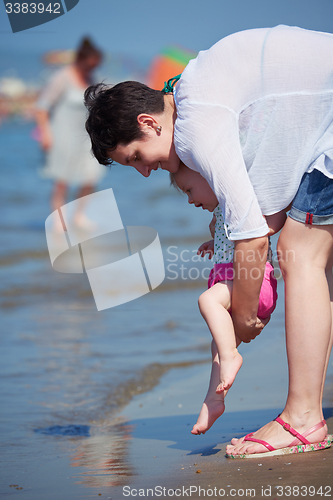 Image of mom and baby on beach  have fun