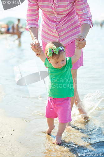 Image of mom and baby on beach  have fun