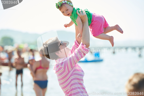 Image of mom and baby on beach  have fun