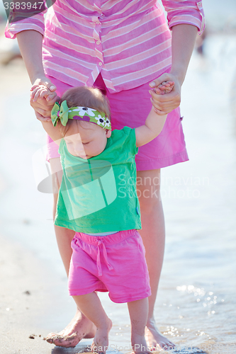 Image of mom and baby on beach  have fun