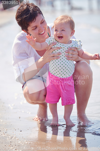 Image of mom and baby on beach  have fun