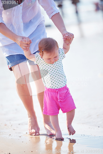 Image of mom and baby on beach  have fun