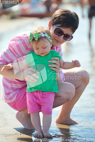 Image of mom and baby on beach  have fun