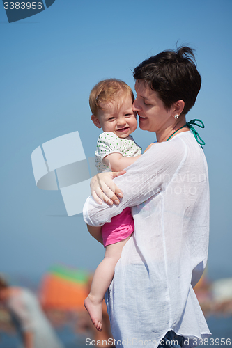 Image of mom and baby on beach  have fun