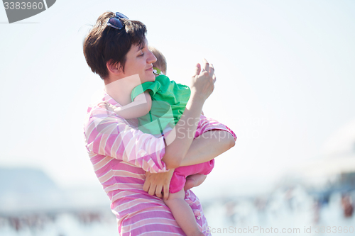 Image of mom and baby on beach  have fun