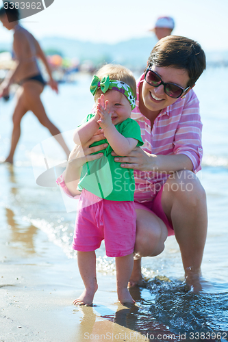 Image of mom and baby on beach  have fun