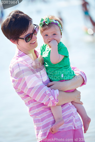 Image of mom and baby on beach  have fun