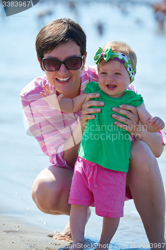 Image of mom and baby on beach  have fun