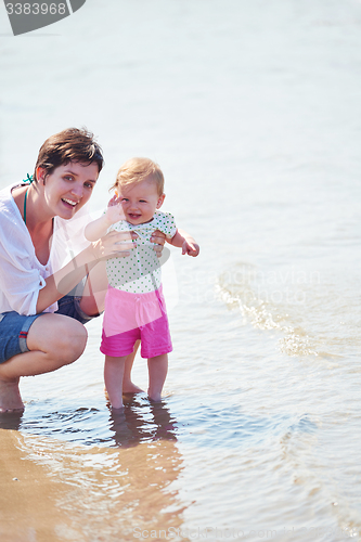 Image of mom and baby on beach  have fun