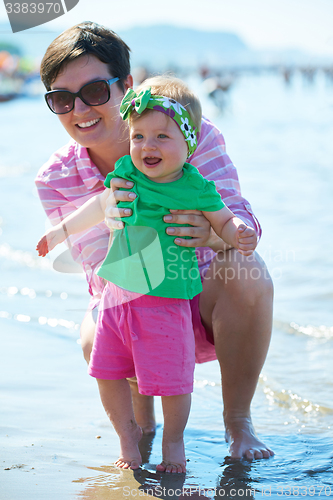 Image of mom and baby on beach  have fun
