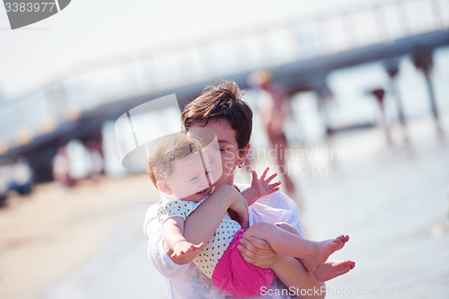 Image of mom and baby on beach  have fun