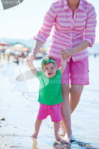 Image of mom and baby on beach  have fun