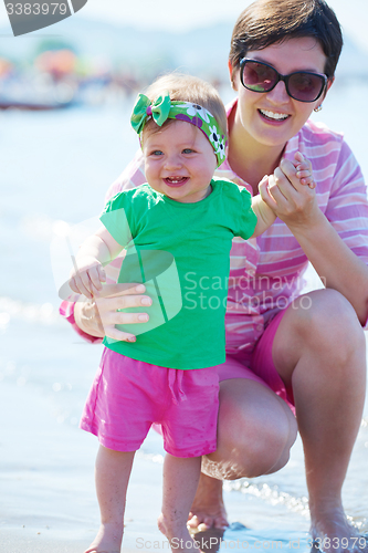 Image of mom and baby on beach  have fun