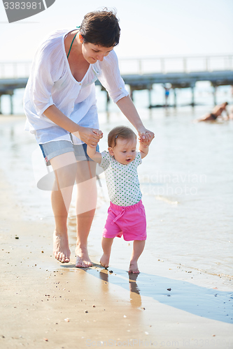 Image of mom and baby on beach  have fun