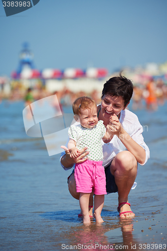 Image of mom and baby on beach  have fun